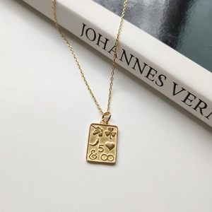 Detailed close-up of a golden coin pendant featuring embossed unicorn and heart symbols