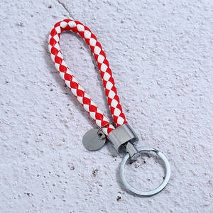 Detailed view of red and white braided leather keychain with polished silver metal ring