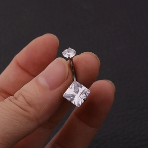 Macro detail of 316L stainless steel belly button ring with round and square cubic zirconia
