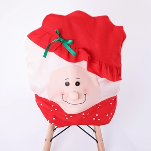 Detail of Christmas Santa chair cover with green ribbon and plush cartoon face design