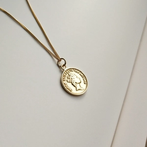 Detailed close-up of 925 sterling silver golden coin necklace with Queen Elizabeth engraving