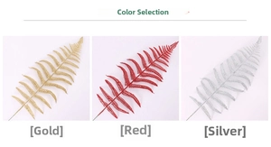 Close-up of glittery artificial fern leaves in gold, red, and silver for Christmas decor
