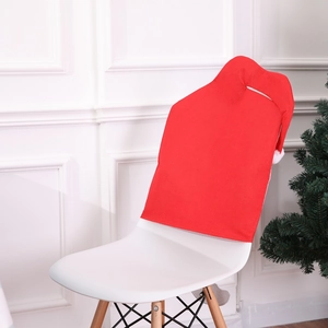 Close-up of red Christmas hat chair covers on white chairs in a cozy festive scene