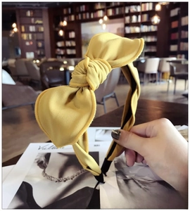Detailed texture of ginger yellow fabric bow headband with soft cloth wrapped frame