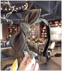 Detailed view of olive green ribbed knit bow headband with elegant texture and knot
