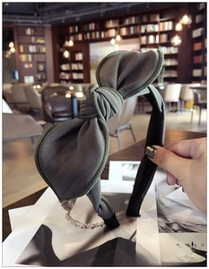 Detail of green fabric bunny ear bow headband featuring twill texture and non-slip lining