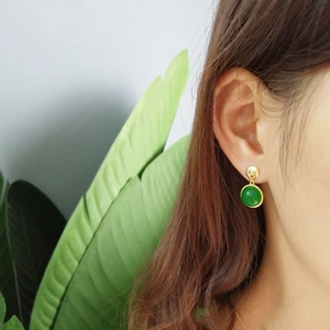 Close-up of green agate stud earrings in gold plating worn for a natural look