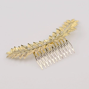 Macro shot of gold leaf-shaped metal hair comb showing detailed leaf veins and prongs