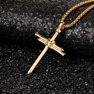 Detail of golden cross pendant made of nails with high-gloss metallic finish