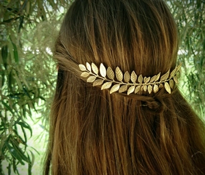 Detail of bohemian gold leaf headpiece worn by a model in a natural setting