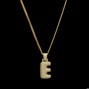 Détail macro du pendentif lettre E bulle glacée avec zircone sur chaîne cubaine dorée