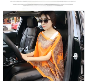 Detail of orange paisley chiffon shawl with delicate white beaded edge trim worn in a car