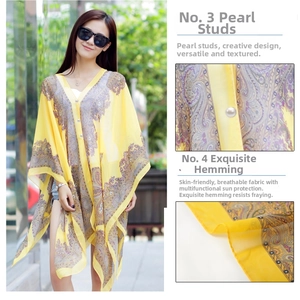 Detail of yellow paisley chiffon sun shawl featuring pearl buckle and fine hem stitching