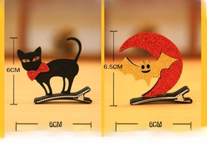Detail of Halloween hair clips featuring a black cat and a sequined bat on moon design