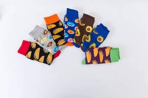 Close-up of vibrant mid-calf cotton socks featuring colorful food patterns on white background