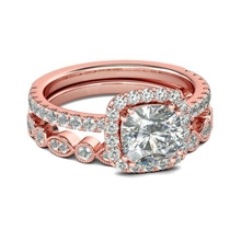 Detail view of a rose gold bridal set featuring a cushion cut halo ring and matching band