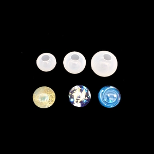 Detailed view of DIY silicone resin sphere molds and finished crystal balls on black background
