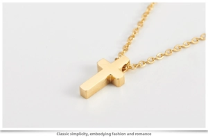 Close-up of rose gold cross pendant showing brushed metal texture and fine chain links