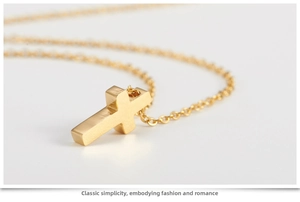 Macro side view of a polished rose gold cross pendant with a fine link chain necklace