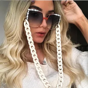 Detail of square oversized sunglasses with pearls and thick matte white acrylic chain