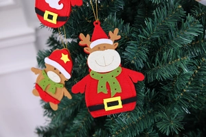 Detail of Christmas reindeer and bear felt ornaments hanging on a festive tree