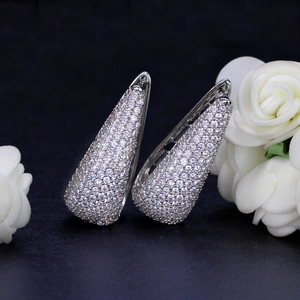 Elegant silver teardrop earrings with pave white zircon on a black display stand