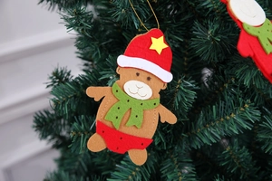 Detailed view of handmade felt bear ornament hanging on a Christmas tree branch