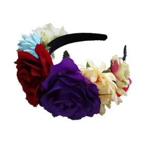 Detailed view of multicolor fabric roses and daisies on a black festive headband
