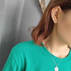 Close-up of asymmetrical 925 silver star and moon stud earrings on a female model
