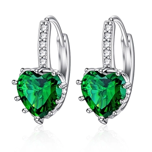 Detail of silver hoop earrings featuring emerald green heart-cut stones and tiny diamonds