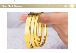 Vue détaillée de trois bracelets joncs dorés ornés de motifs grecs classiques de méandres