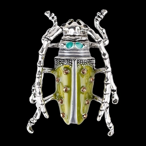 Vintage enamel grasshopper brooch with green crystals and silver finish on black background