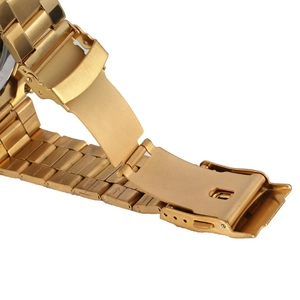 Detail of the golden stainless steel folding clasp and polished metal watch strap texture