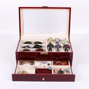 Detail showing red wood watch box with clear glass lid and beige velvet lining interior
