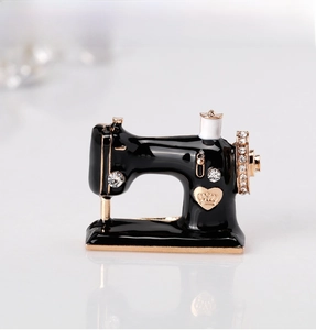 Macro shot of sewing machine brooch with black enamel, crystals and gold crown heart