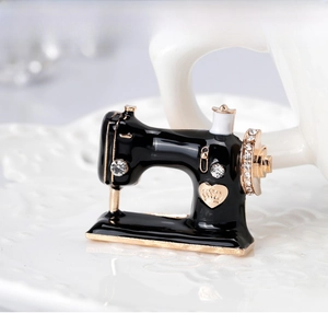 Detail of sewing machine brooch with black enamel, gold accents and crystals