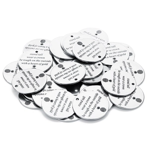 Detailed macro view of 5 silver stainless steel DIY pendant charms with engraved quote