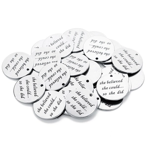 Macro detail of engraved silver stainless steel discs for DIY jewelry necklaces