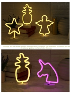 Detail of neon LED night lights in star, pineapple and unicorn shapes with round base