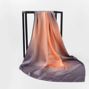 Detailed view of large floral satin silk square scarf with orange-grey gradient transitions