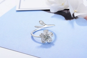Macro shot of silver cherry blossom ring with matte petals and a sparkling zircon stone