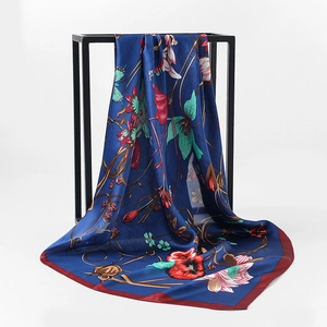 Detail of silk satin square scarf showing vibrant floral patterns and smooth drape texture