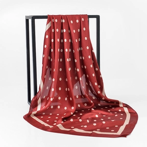Detailed macro shot of red satin silk scarf with white polka dots on a display stand
