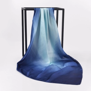 Detail of gradient blue silk scarf with satin texture draped on black metal stand