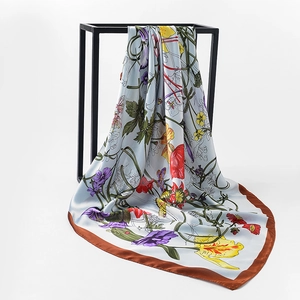 Detail of silk square scarf showing floral tulip patterns draped on a black metal stand