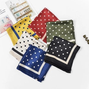 Macro shot of colorful satin polka dot scarves overlapping with elegant floral accents