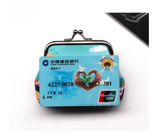 Mini kiss-lock coin purse with artistic landscape print shown next to a bank card