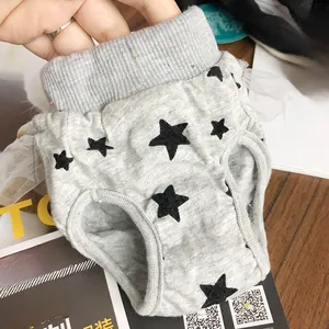 Detail of dog hygiene pants with black stars pattern and elegant white lace trim