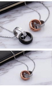 Detail of interlocking double ring pendant necklace with engraved love quotes and crystals
