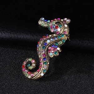 Macro shot of seahorse brooch featuring vintage gold base and colorful rhinestones